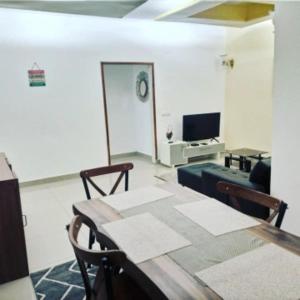 a living room with a table and a television at Logement paisible à Mpita in Pointe-Noire