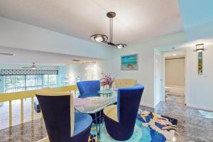 a dining room with a glass table and blue chairs at Ms Aloha on Siesta Key in Sarasota