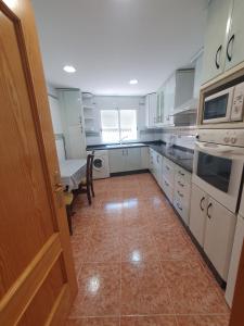 a kitchen with white cabinets and a tile floor at Apartamento para 6 personas en Alcalá de Xivert in Alcalá de Chivert
