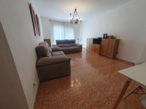 a living room with a couch and a television at Apartamento para 6 personas en Alcalá de Xivert in Alcalá de Chivert