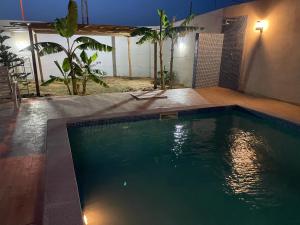 a swimming pool in a backyard at night at Dar aissa in Aghīr
