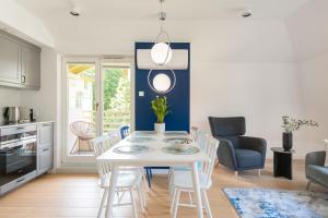 a kitchen and dining room with a white table and chairs at Sopot M16 - by JWPM in Sopot
