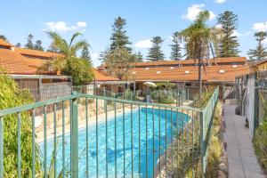 a swimming pool with a green fence around it at 11 Cottesloe - steps from beach - sleeps 3 in Perth