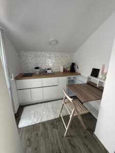 a small kitchen with a table and a chair at Vila Ema in Bajina Bašta