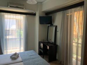 a bedroom with a bed and a dresser and a mirror at Kekrops Hotel in Loutra Edipsou