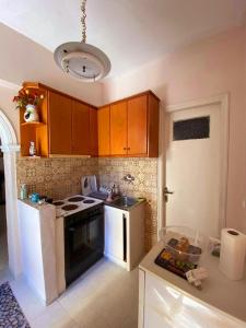a kitchen with brown cabinets and a white stove top oven at Palaiopolis house in Kanoni