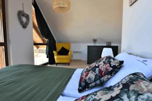 Borowy MłynにあるDomek na Kaszubach 3-2 - Ostoja Bukowoのベッドルーム1室(ベッド1台、黄色い椅子付)