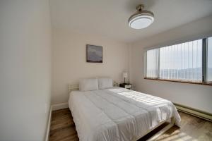 a white bedroom with a bed and a large window at Bright Gadsden Apartment about 10 Mi to Dive Land Park in Gadsden
