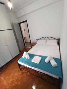 a bedroom with a bed with two towels on it at Olympus Terra Apartments No1 in Litochoro +12 photos