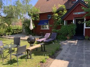 a patio with chairs and a grill in front of a building at Villa Linneryd 1 in Linneryd