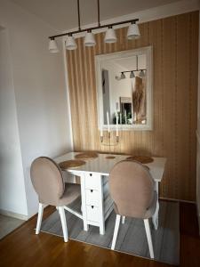 a dining room table with two chairs and a mirror at Sea apartment Bar in Bar