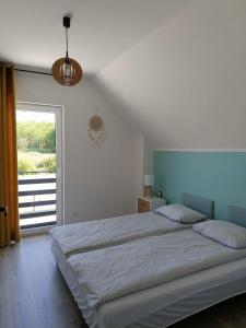 Un dormitorio con una cama grande y una ventana grande. en Domki całoroczne Perełka Lubiatowska, en Lubiatowo 44 fotos más