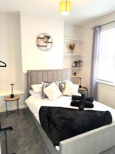 a bedroom with a large bed with black blankets and pillows at Ty Noah- Newly Refurbished Home In The Heart Of Pembrokeshire in Milford Haven