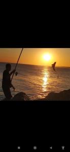 a man fishing on the beach at sunset at Loft Necochea in Necochea