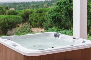 a bath tub sitting on a balcony with a view of trees at Montum Farm Living in Melides