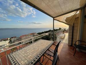 a table on a balcony with a view of the water at Guest house Adria in Dugi Rat
