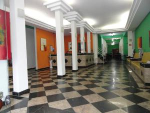 a lobby with a checkered floor and columns in a building at Hotel Royal Class in Guaratinguetá