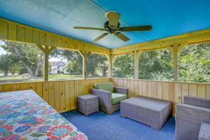 a screened in porch with a ceiling fan and chairs at Maryland Retreat Walk to Bay, Beach and Boat Ramp! in Deal Island