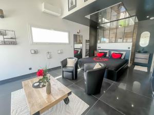 a living room with a bed and a table at Maison 8 personnes avec piscine et jacuzzi in Rosières