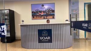 a man is standing behind a podium in a room at Voar Pousada in Barreirinhas