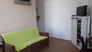 ein Wohnzimmer mit Sofa und Fernseher in der Unterkunft Studio vue mer 1r étage avec balcon in Les Sables-dʼOlonne