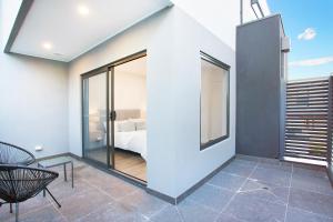 a room with a bed and a glass wall at Stud Park Residence by Ready Set Stay in Rowville