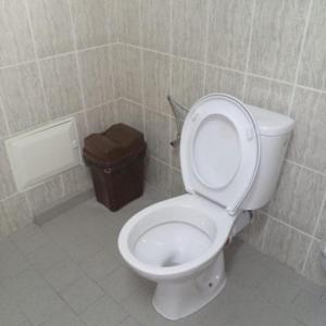 a bathroom with a toilet and a trash can at Magnifique studio à Mpita in Pointe-Noire