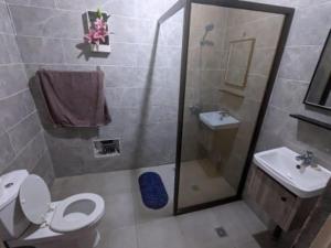 a bathroom with a shower and a toilet and a sink at Magnifique studio à Mpita in Pointe-Noire