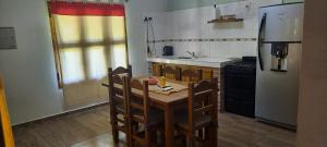 Una cocina con mesa y sillas y un refrigerador. en El Nevado Casa de Campo 1, en San Rafael