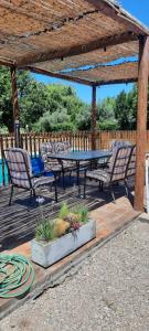 una mesa de picnic y 2 sillas bajo una pérgola de madera en El Nevado Casa de Campo 1, en San Rafael