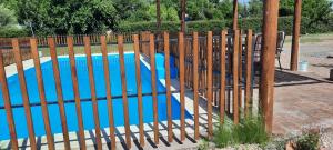 Una valla alrededor de una piscina con una piscina azul. en El Nevado Casa de Campo 1, en San Rafael