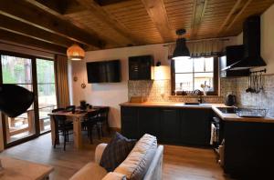 a kitchen and living room with a couch and a table at Domek na Kaszubach 7-1 - Ostoja Bukowo in Borowy Młyn