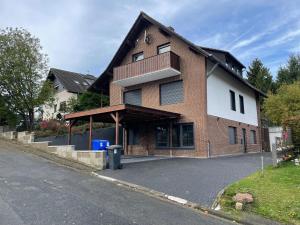 a brick house with a balcony on a street at Wellness Suite für 2 Personen mit Sauna und Billardtisch in Altenau