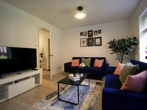 a living room with a blue couch and a tv at 2BDR Flat RG1 - Free Open Parking in Reading