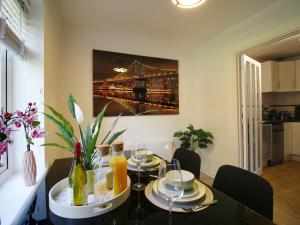 a dining room table with a picture of a bridge at 2BDR Flat RG1 - Free Open Parking in Reading +29 photos
