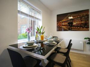 a dining room table with chairs and a painting on the wall at 2BDR Flat RG1 - Free Open Parking in Reading