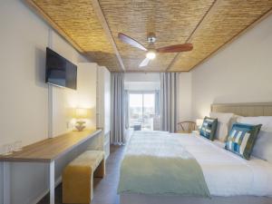 ein Schlafzimmer mit einem Bett und einem Deckenventilator in der Unterkunft Hotel Punta Lara Noirmoutier in La Guérinière