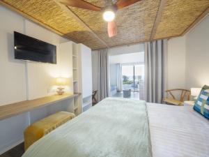 a bedroom with a large bed and a television at Hotel Punta Lara Noirmoutier in La Guérinière