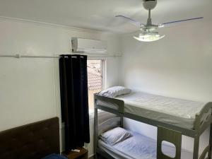a room with two bunk beds and a window at Apartamento pé na areia praia Tombo in Guarujá