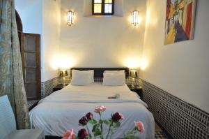 a bedroom with a bed with flowers on it at Riad Adarissa in Fès +68 photos