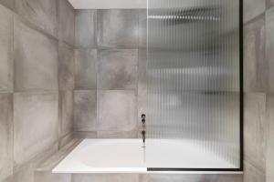 une douche avec une porte vitrée dans une salle de bain dans l'établissement Stunning Mountain Views in Queenstown-Hot tub, à Queenstown 56 autres photos