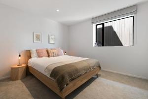 une chambre avec un grand lit et une fenêtre dans l'établissement Stunning Mountain Views in Queenstown-Hot tub, à Queenstown