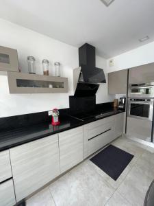 une cuisine avec un comptoir noir dans une pièce dans l'établissement Villa avec piscine 35 min de Paris, à Étiolles