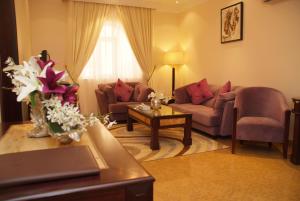 a living room filled with furniture and flowers at Garden Hotel Muscat in Muscat