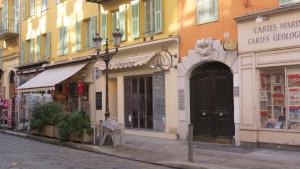 a city street with shops and a black door at Apartment Massena in Nice