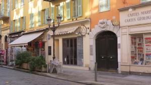 una calle de la ciudad con tiendas y una puerta negra en Apartment Massena, en Niza