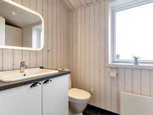 een badkamer met een toilet, een wastafel en een spiegel bij 4 star holiday home in Væggerløse-By Traum in Bøtø By +47 foto's