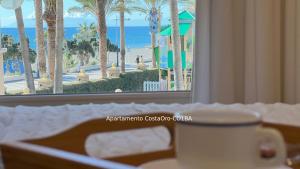 a hotel room with a table with a view of the beach at CostaOro in Torrox Costa