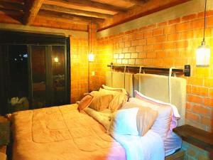 a bedroom with a large bed in a brick wall at Villa sasa in Curití +13 photos