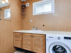a bathroom with a sink and a washing machine at 6 person holiday home in Gedser-By Traum in Gedser +10 photos